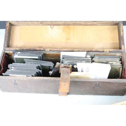 605 - A collection of over 100 glass magic lantern slides contained within three wooden boxes to include A... 