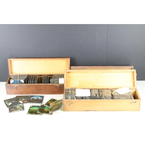 622 - A collection of approx 150 x glass magic lantern slides contained within three wooden cases to inclu... 