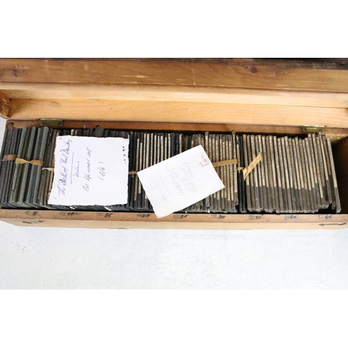 622 - A collection of approx 150 x glass magic lantern slides contained within three wooden cases to inclu... 