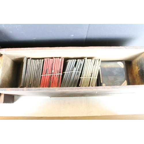 622 - A collection of approx 150 x glass magic lantern slides contained within three wooden cases to inclu... 