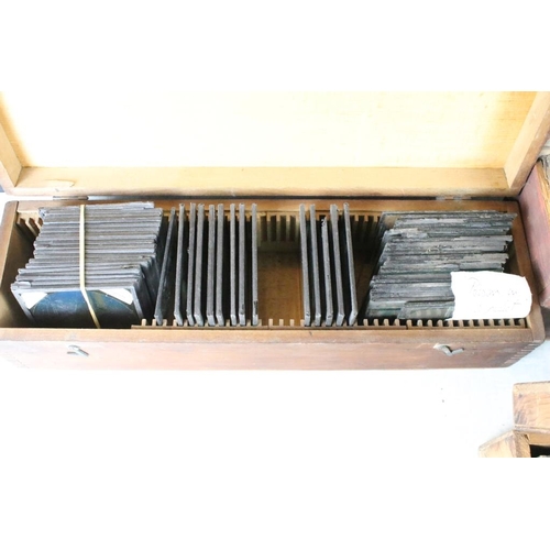 622 - A collection of approx 150 x glass magic lantern slides contained within three wooden cases to inclu... 