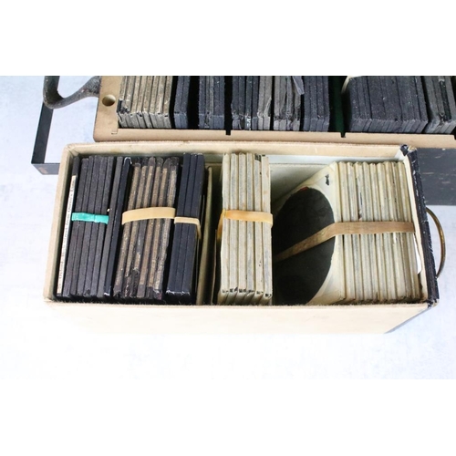 624 - A collection of approx 100 x glass magic lantern slides contained within three wooden cases to inclu... 