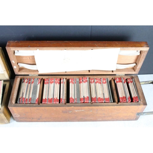 626 - A collection of over 100 x glass magic lantern slides contained within three wooden cases to include... 