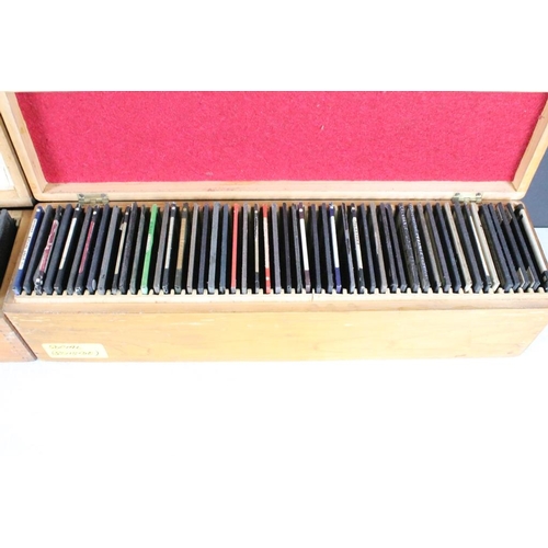 627 - A collection of over 100 glass magic lantern slides contained within three wooden cases to include t... 