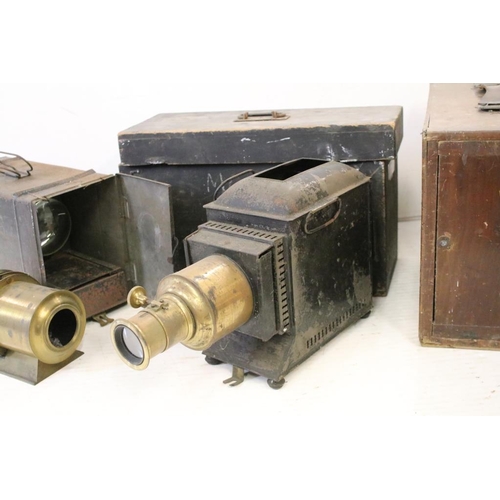 633 - A collection of three magic lantern projectors contained within storage cases. (A/F).