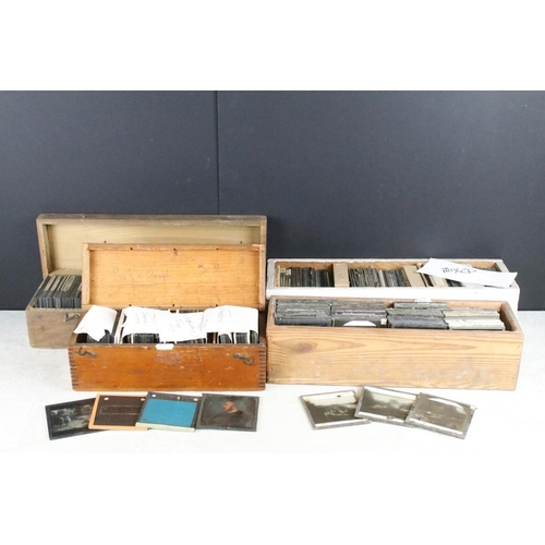 636 - A collection of over 100 mixed glass magic lantern slides contained within four wooden cases to incl... 