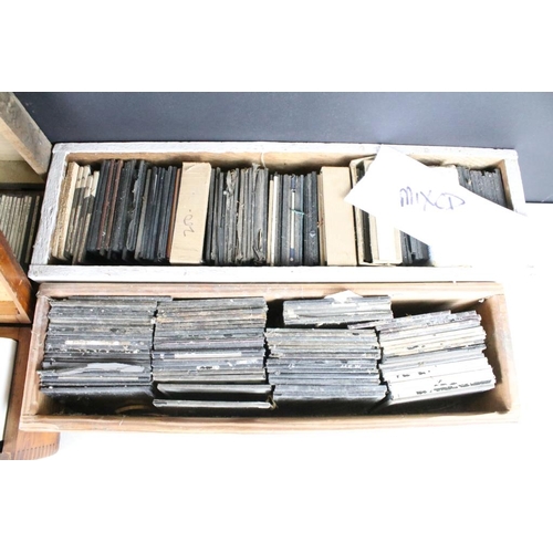 636 - A collection of over 100 mixed glass magic lantern slides contained within four wooden cases to incl... 