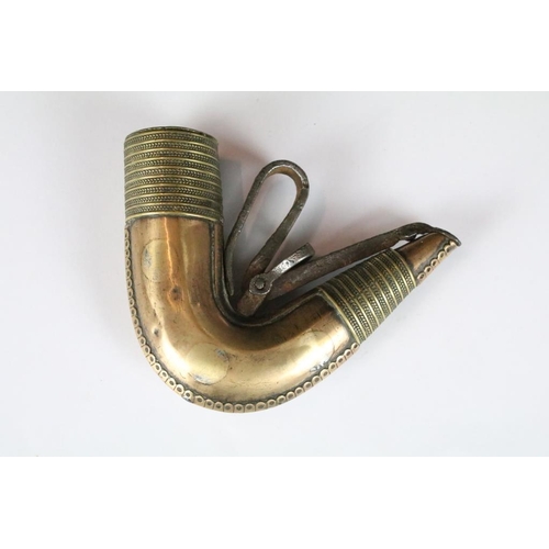 207 - An antique brass Islamic powder flask together with a white metal example.