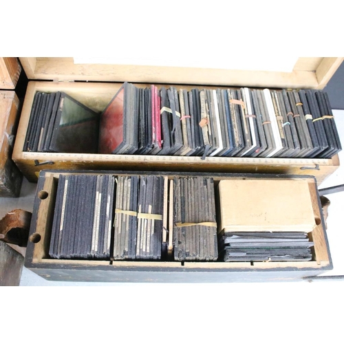 637 - A collection of over 100 glass magic lantern slides contained within four wooden cases to include Re... 