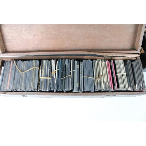 637 - A collection of over 100 glass magic lantern slides contained within four wooden cases to include Re... 