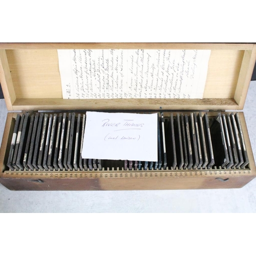 641 - A collection of over 50 glass magic lantern slides contained within two wooden cases, all topographi... 