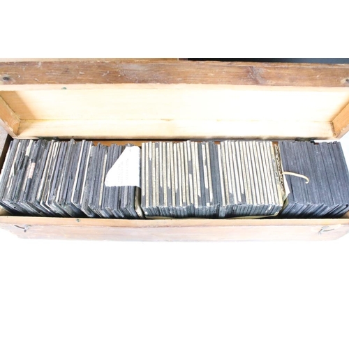 642 - A collection of over 100 glass magic lantern slides contained within three wooden cases to include p... 