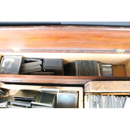 642 - A collection of over 100 glass magic lantern slides contained within three wooden cases to include p... 