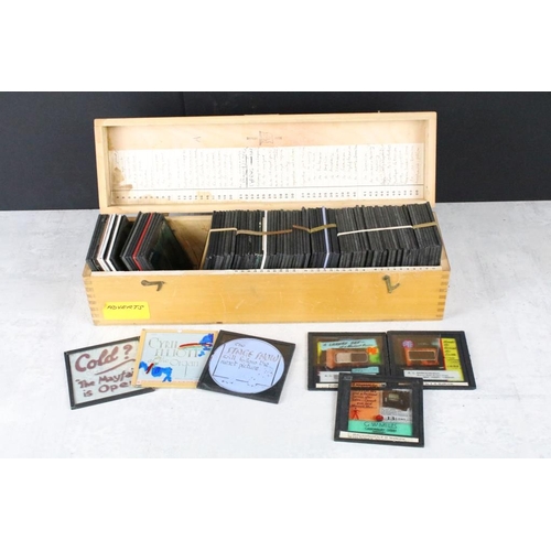 645 - A collection of approx 50 glass magic lantern slides contained within a wooden case to include adver... 