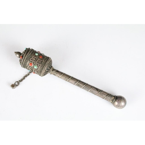 237 - A white metal Tibetan prayer wheel set with red and blue cabochons together with an amulet.