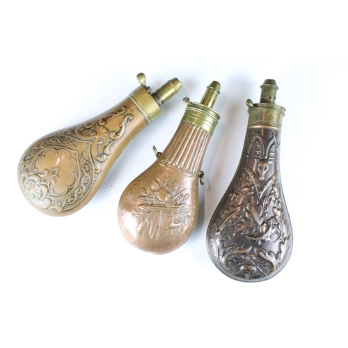 259 - A group of three antique copper powder flasks with brass fittings.