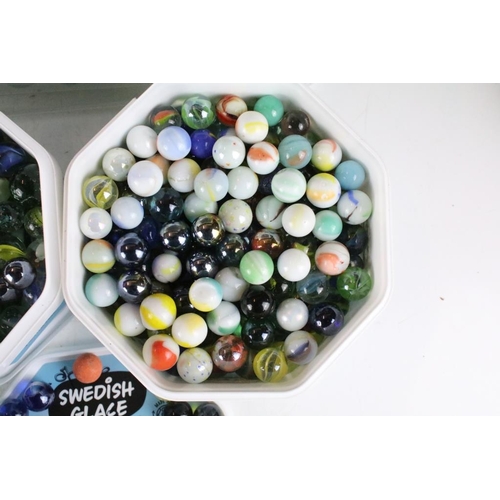 303 - A large collection of mixed glass marbles contained within six boxes.