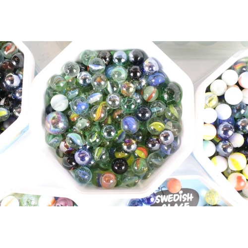 303 - A large collection of mixed glass marbles contained within six boxes.