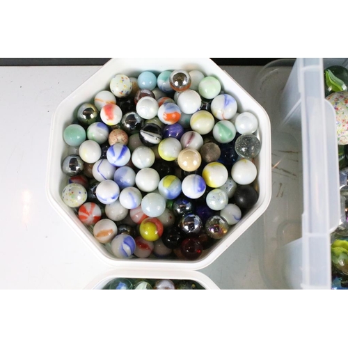 303 - A large collection of mixed glass marbles contained within six boxes.