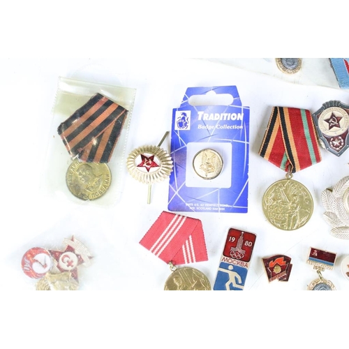 308 - A collection of Russian military medals together with a selection of Russian badges.