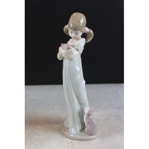 47 - Three Lladro figurines to include a boy holding a model ship, lady with a hare and a girl with a kit... 