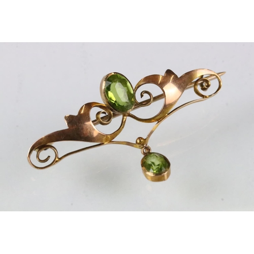 177 - Edwardian peridot 9ct yellow gold brooch, the principal oval mixed cut peridot measuring approx 7.5 ... 