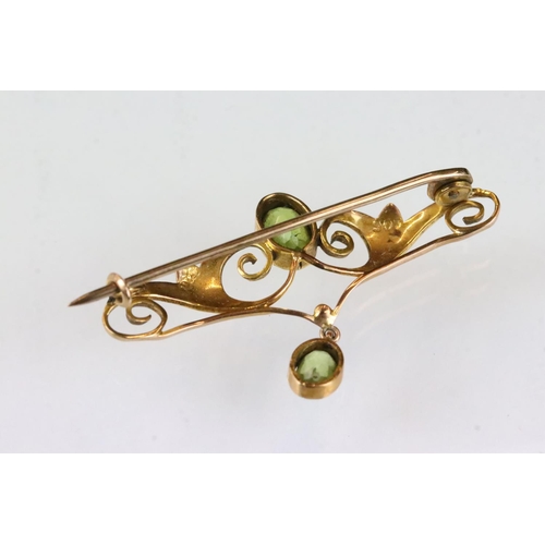 177 - Edwardian peridot 9ct yellow gold brooch, the principal oval mixed cut peridot measuring approx 7.5 ... 