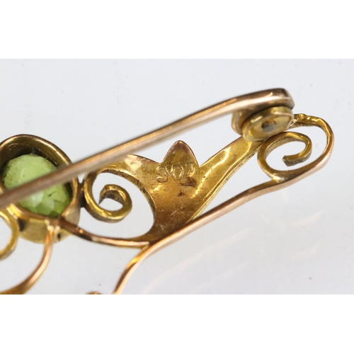 177 - Edwardian peridot 9ct yellow gold brooch, the principal oval mixed cut peridot measuring approx 7.5 ... 