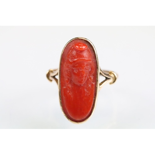 32 - 19th century coral 9ct gold ring, the carved coral modelled as a female head with hat, rubover set, ... 