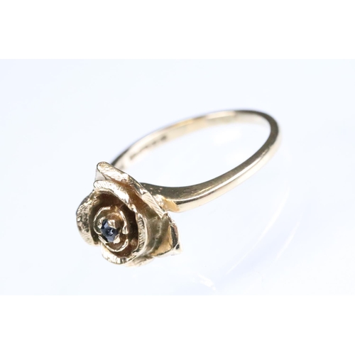 148 - Sapphire 9ct rose gold ring modelled as a rose flower, small blue-back sapphire to centre, size of h... 