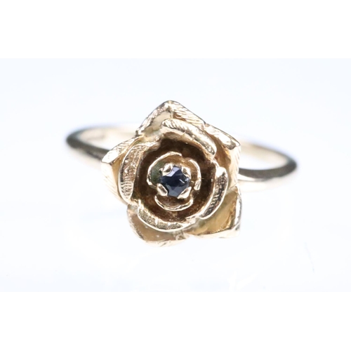 148 - Sapphire 9ct rose gold ring modelled as a rose flower, small blue-back sapphire to centre, size of h... 