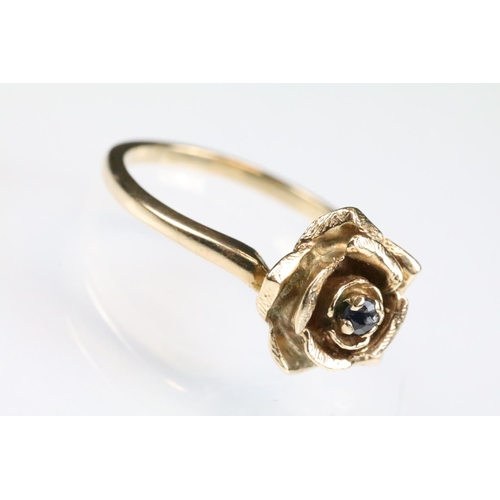 148 - Sapphire 9ct rose gold ring modelled as a rose flower, small blue-back sapphire to centre, size of h... 