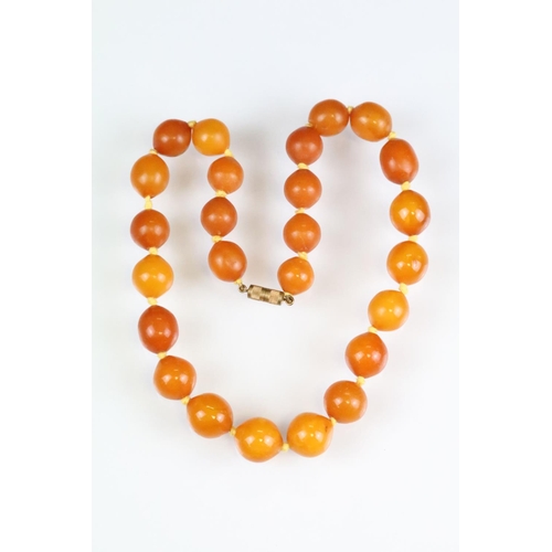 38 - Early 20th century butterscotch amber-style necklace, screw barrel clasp, twenty-five beads, the lar... 