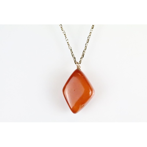 39 - Butterscotch amber-style pendant, rose metal mount, the  lozenge-shaped pendant dimensions approx 3.... 