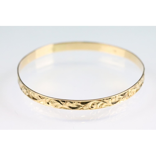 45 - Four 18ct yellow gold bangles, foliate scroll decoration in relief, width approx 5mm, interior diame... 