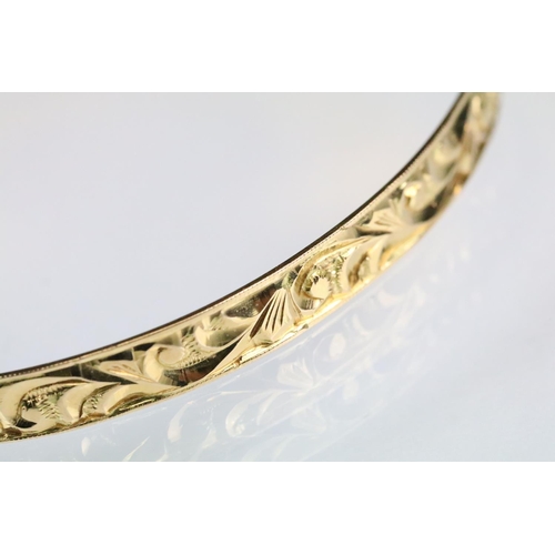 45 - Four 18ct yellow gold bangles, foliate scroll decoration in relief, width approx 5mm, interior diame... 