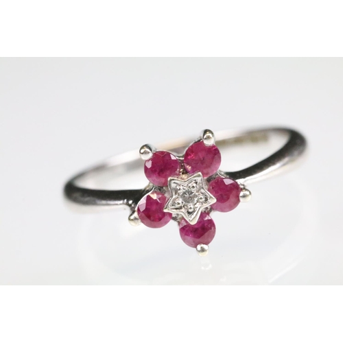 91 - Ruby and diamond 9ct white gold flower head ring, central small round eight cut diamond to centre, i... 