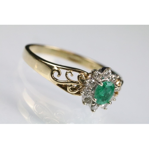 92 - Emerald and diamond 9ct yellow and white gold flower head cluster ring, the oval mixed cut emerald m... 