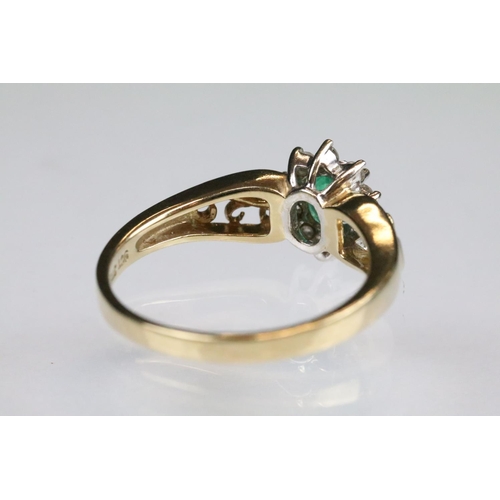 92 - Emerald and diamond 9ct yellow and white gold flower head cluster ring, the oval mixed cut emerald m... 