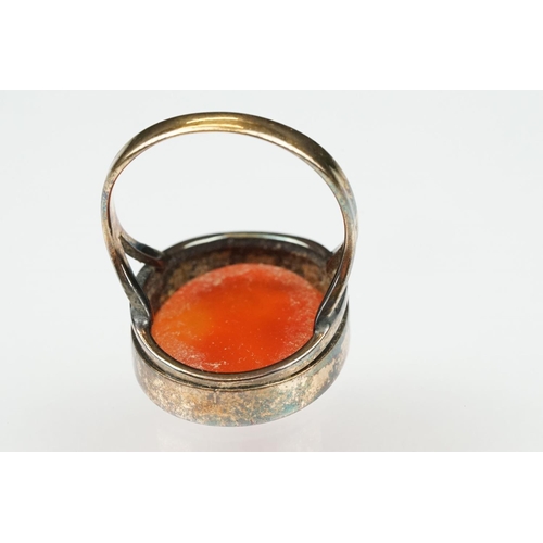 104 - Carnelian intaglio gilt metal ring, the oval carnelian intaglio depicting Roman head facing left, di... 