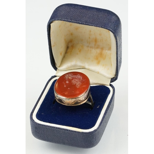 104 - Carnelian intaglio gilt metal ring, the oval carnelian intaglio depicting Roman head facing left, di... 