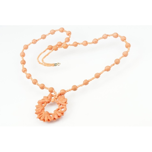 107 - Early 20th century coral 9ct gold necklace, the principal carved coral disc depicting lotus flowers,... 