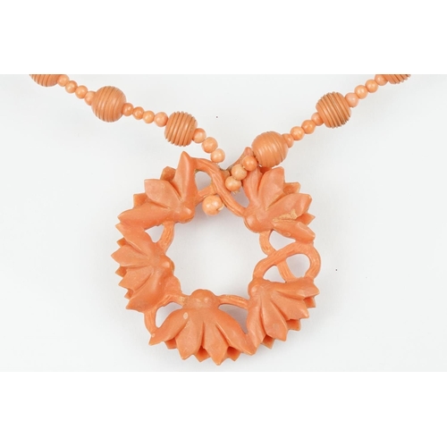 107 - Early 20th century coral 9ct gold necklace, the principal carved coral disc depicting lotus flowers,... 