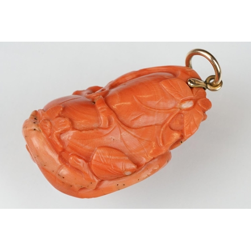 27 - Early 20th century carved coral pendant, the coral depicting long-tailed mammal, butterflies and flo... 