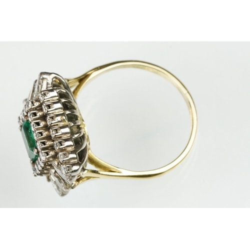 29 - Emerald and diamond 18ct yellow and white gold cluster ring, the central emerald cut emerald measuri... 