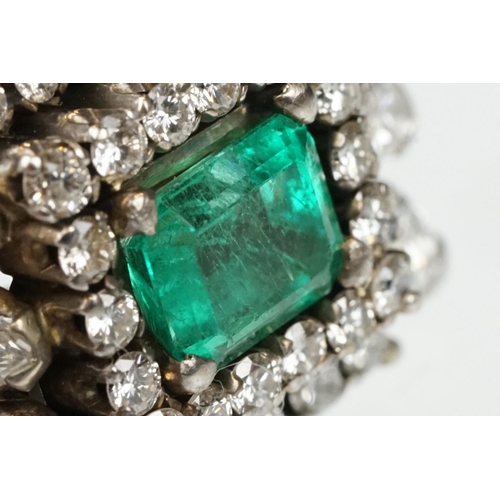 29 - Emerald and diamond 18ct yellow and white gold cluster ring, the central emerald cut emerald measuri... 