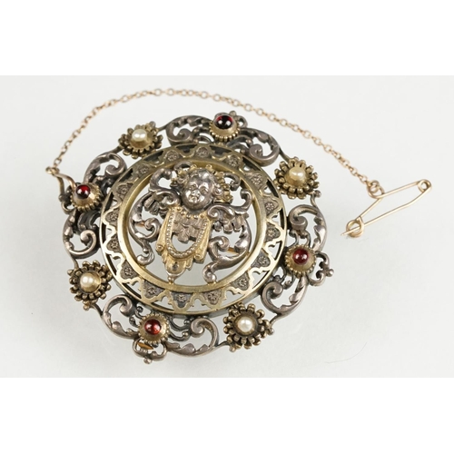 114 - Indian seed pearl and garnet unmarked parcel gilt silver brooch, the centre depicting cast cherub fa... 