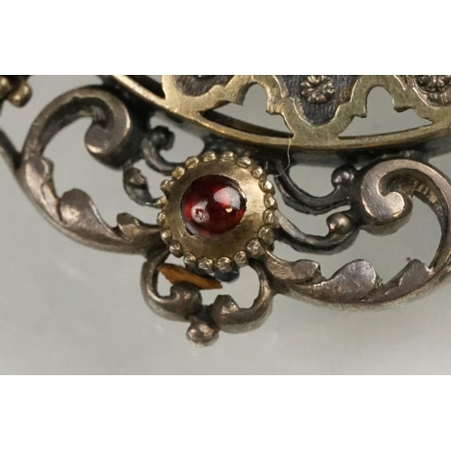 114 - Indian seed pearl and garnet unmarked parcel gilt silver brooch, the centre depicting cast cherub fa... 