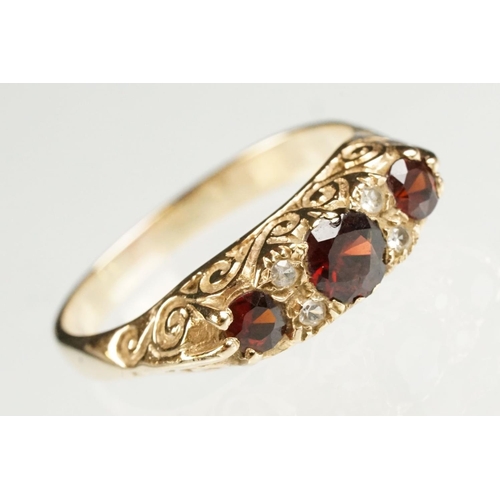 117 - Garnet 9ct yellow gold boat head ring, three graduated round mixed cut rubies, the principal ruby di... 