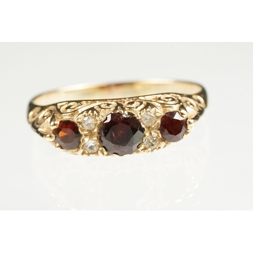 117 - Garnet 9ct yellow gold boat head ring, three graduated round mixed cut rubies, the principal ruby di... 